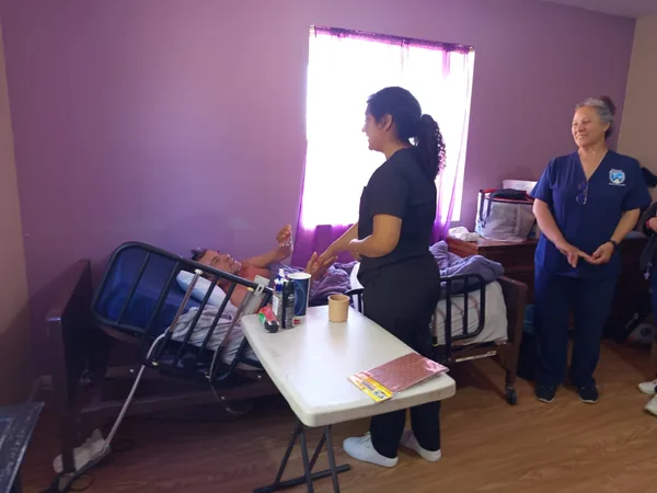Alumna atendiendo a una residente de la casa de reposo junto a su enfermera