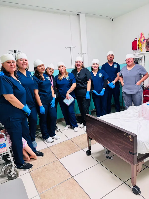 Grupo con gorro y guantes listo para la práctica en el laboratorio