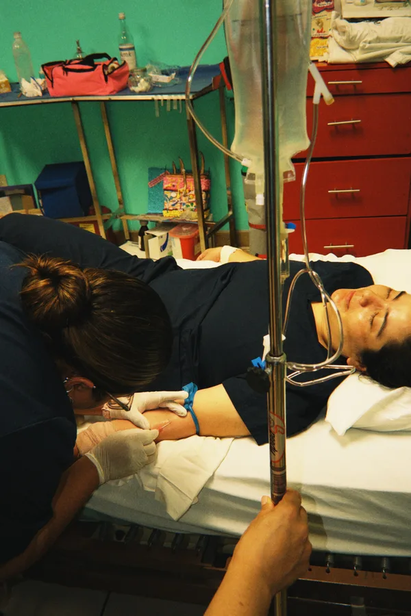 Alumna canalizando una vía intravenosa a una compañera en el laboratorio