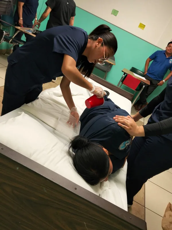 Alumnas practicando la movilización de una paciente en cama