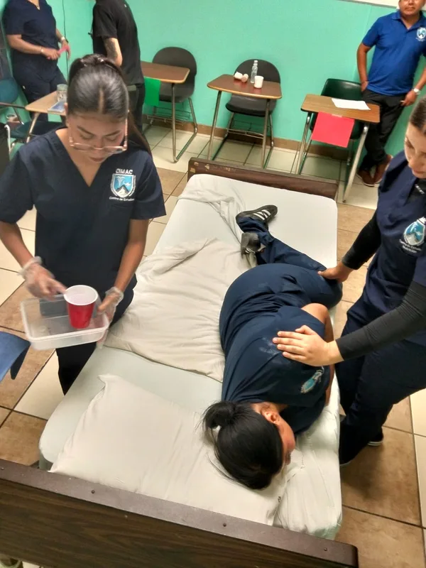 Práctica de cambio de posición de una paciente en la cama de hospital