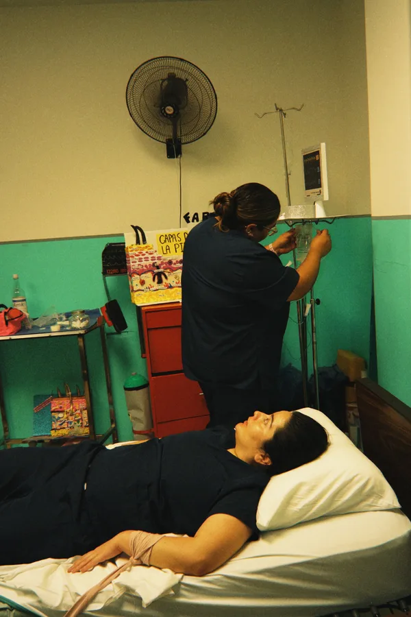 Alumna ajustando el suero de una paciente en la cama de prácticas